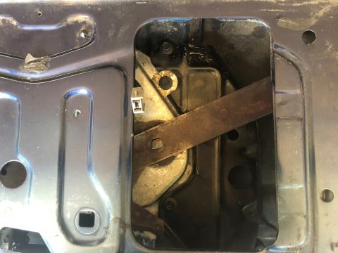 1995 Ford Bronco - The internal mechanism of a tailgate window regulator shows signs of rust and wear.