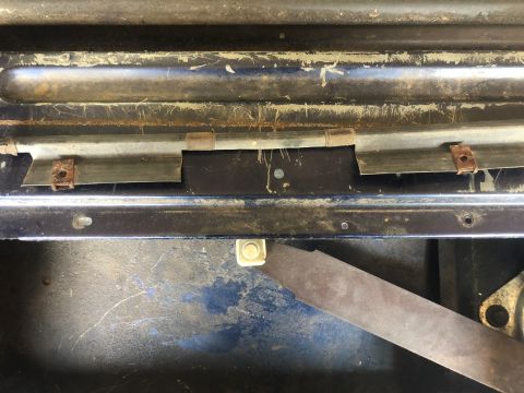 1995 Ford Bronco - Close-up view of a tailgate repair mechanism, showing internal metal components and blue painted surfaces.