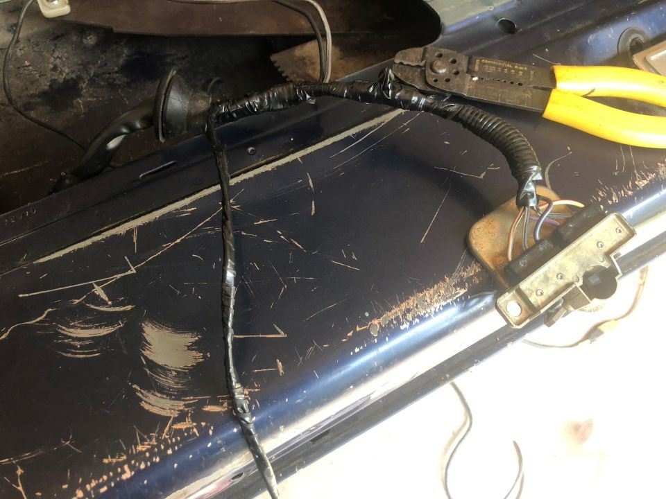 tailgate wiring with electrical tape and wire strippers