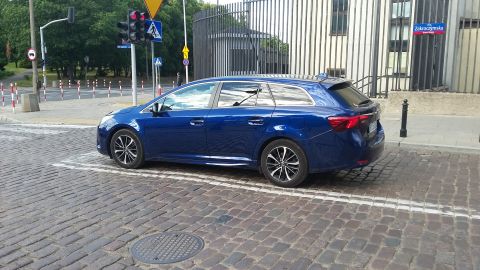 Blue station wagon parked on cobblestone street