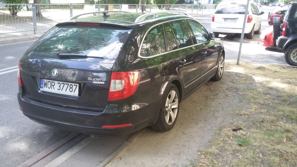 Dark station wagon with license plate WOR 37787 parked on a street next to other vehicles