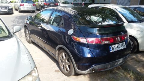 Dark blue 2006 Honda Civic hatchback rear view, parked next to other cars. License plate WY-8044K
