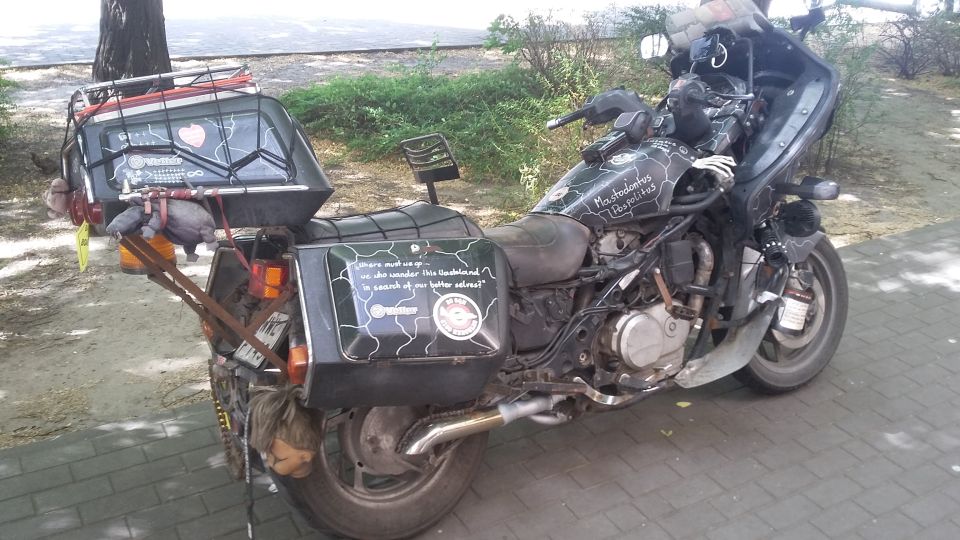 Motorcycle with extensive luggage, custom paint, and a doll hanging from the rear