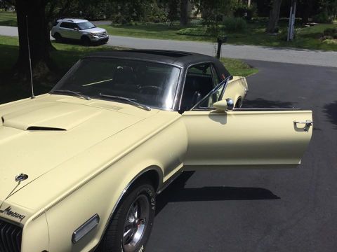 1968 Mercury Cougar - A 1968 Mercury Cougar is parked in a driveway with its door open; a modern SUV is visible in the background.