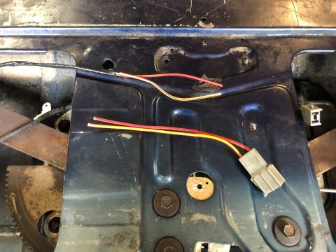 1995 Ford Bronco - Wiring harness and mechanical components visible inside a vehicle door panel, likely for window or lock operation.