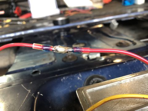 1995 Ford Bronco - A close-up view shows a spliced electrical wire with heat shrink tubing, indicating a repair rather than a vehicle part.