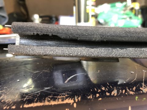 1995 Ford Bronco - A close-up view of a damaged rubber seal, likely from a vehicle's tailgate or window.
