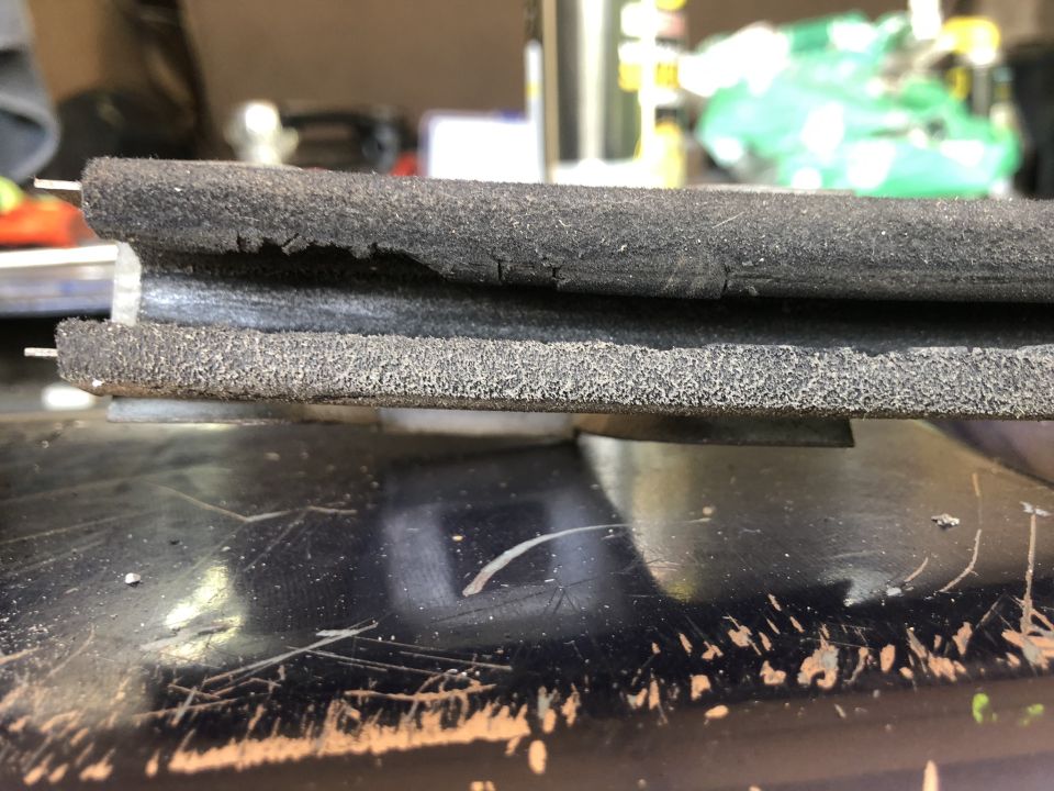 Close-up of a worn rubber seal with metal backing
