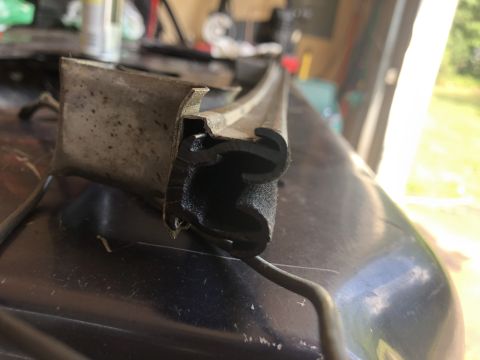 1995 Ford Bronco - Close-up of a rubber seal and metal bracket, likely a car part.