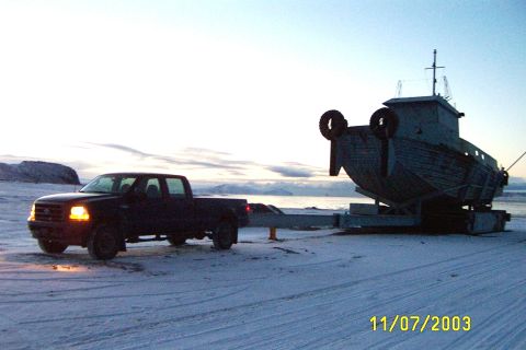 1996 Ford Bronco - A black Ford F-350 pickup truck tows a boat on a trailer across a snowy landscape under a pale sky.