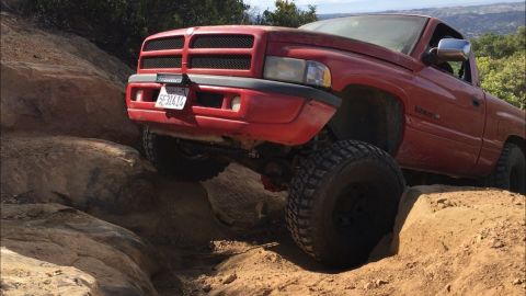 1996 Dodge 1500 - A red Dodge Ram pickup truck is shown off-roading on a challenging rocky path.