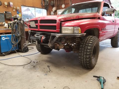 1996 Dodge 1500 - A red 1996 Dodge 1500 pickup truck is shown in a garage, a custom front bumper with an integrated winch.