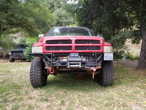 1996 Dodge 1500 - A red Dodge Ram pickup truck is parked outdoors with a winch mounted on the front bumper. A second truck is partially visible in the backgr…