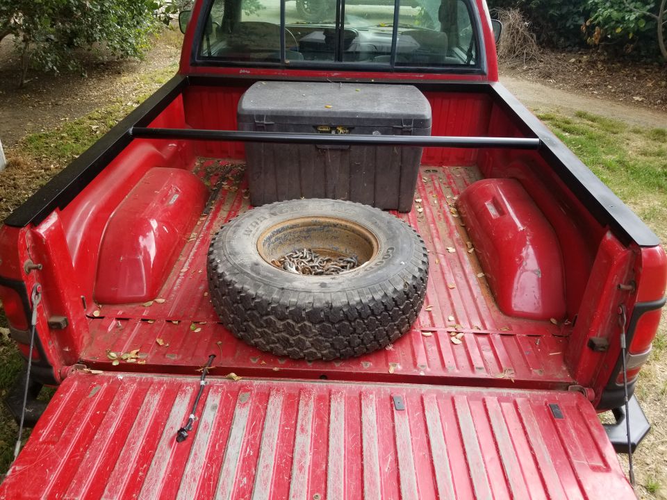 1996 Dodge 1500 pickup truck bed interior with spare tire, toolbox, and bedliner