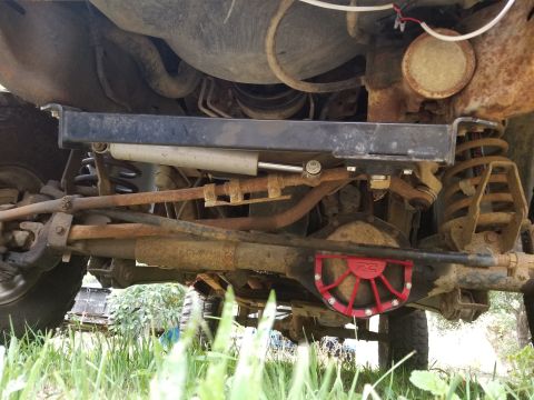 1996 Dodge 1500 - The underside of a truck shows its suspension components, steering linkage, and a red differential cover.