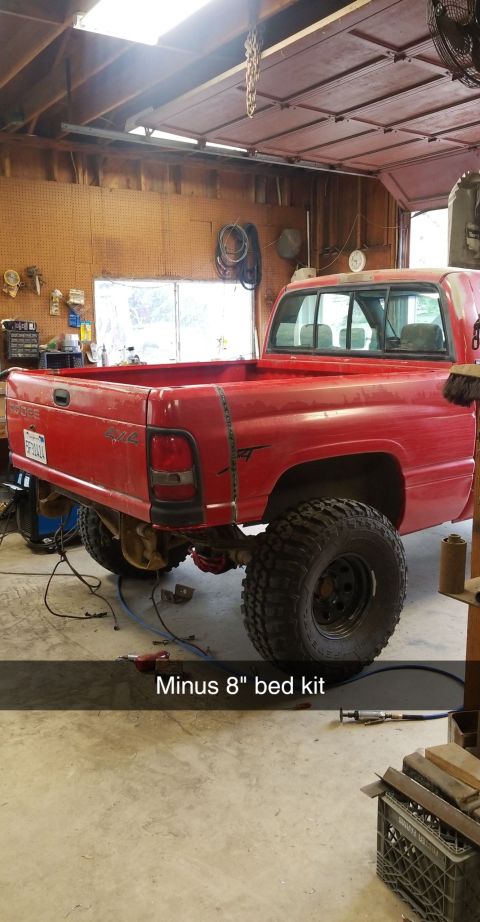 1996 Dodge 1500 - Rear view of a red 1996 Dodge 1500 pickup truck undergoing modifications in a workshop.