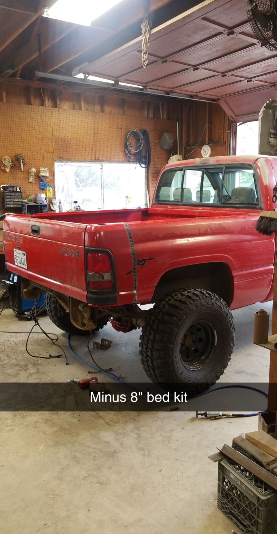 1996 Dodge 1500 pickup truck, rear view, in a garage with modified suspension and large tires