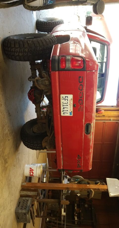 1996 Dodge 1500 - This red Dodge pickup truck is shown from the rear, with its tailgate and California license plate visible.