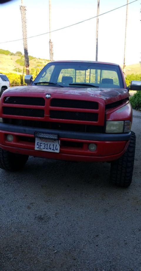1996 Dodge 1500 - Front view of a red Dodge Ram pickup truck with a black grille and a license plate.