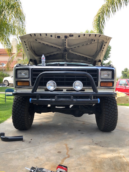 1981 Ford Bronco - This Ford F-Series truck, likely from the early 1980s, is parked in a driveway with its hood up and a bull bar attached to the front.