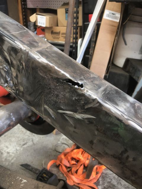1992 Jeep Wrangler - The metal frame shows significant damage, including a hole and numerous scratches, indicating a need for repair.