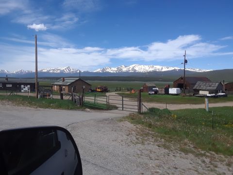 1999 Ford E250 - A rural landscape unfolds with farm buildings and a distant mountain range under a blue sky.