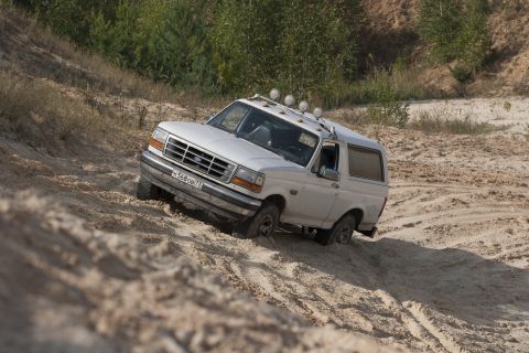 1993 Ford Bronco - This 1993 Ford Bronco is navigating a challenging sandy terrain, demonstrating its off-road capabilities.