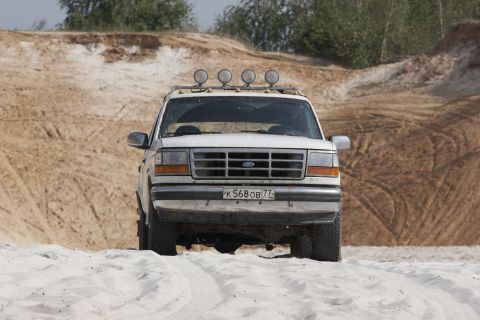 1993 Ford Bronco - White 1993 Ford Bronco parked in a sandy area with tire tracks.