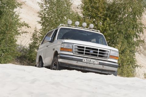 1993 Ford Bronco - This 1993 Ford Bronco navigates a sandy terrain, equipped with auxiliary lights on its roof rack.