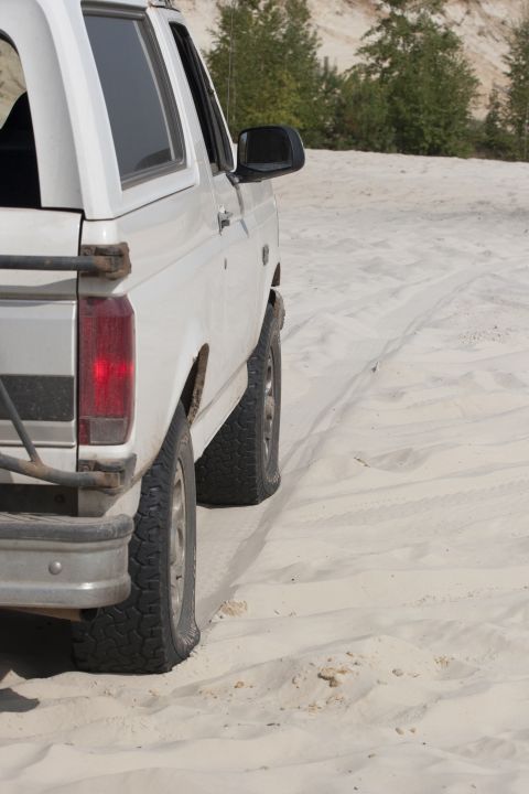 1993 Ford Bronco - This 1993 Ford Bronco is seen from the side, navigating a sandy landscape.