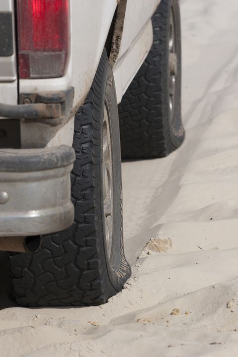 1993 Ford Bronco - The vehicle appears to be stuck in the sand with at least one flat tire.