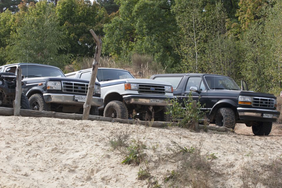Three 1992 Ford Broncos parked on a sandy slope