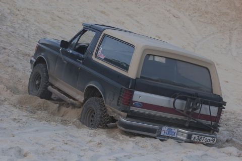1993 Ford Bronco - This Ford Bronco is partially submerged in sand, with its rear facing the camera.