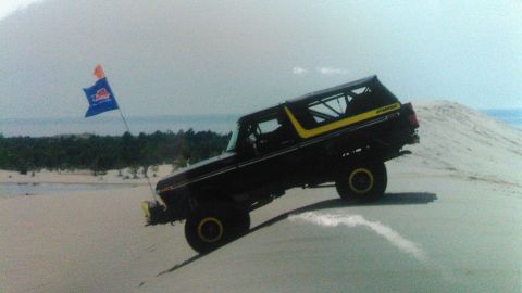 1978 Ford Bronco - This 1978 Ford Bronco is shown navigating a sandy terrain, with a flag flying from its antenna.