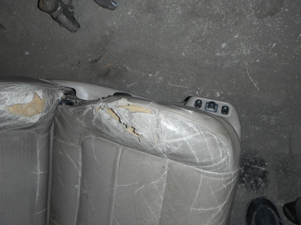 Torn gray leather car seat interior
