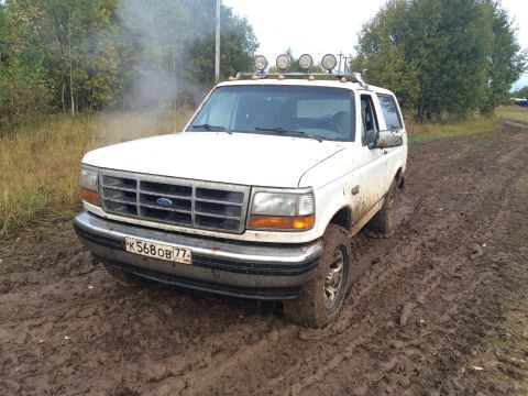 1993 Ford Bronco - This 1993 Ford Bronco is stuck in a muddy field, with smoke billowing from under the hood.