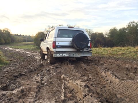 1993 Ford Bronco - Ford Bronco navigating a muddy track off-road.