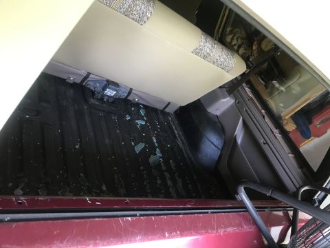 1994 Ford Bronco - The cargo area of the vehicle shows debris scattered across the floor, with the rear seat folded up.