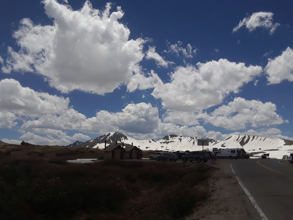 mountain scene with parked cars and an RV
