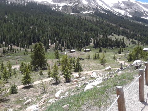 1999 Ford E250 - A scenic view of a mountain valley dotted with cabins and surrounded by dense pine forest.