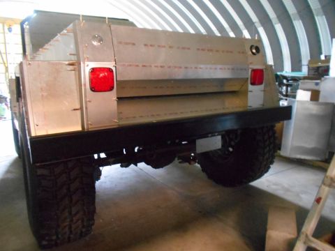 1992 Ford Bronco - A custom truck with a silver aluminum bed is shown from the rear, parked indoors.