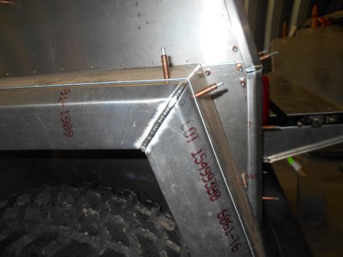 1992 Ford Bronco - Welded aluminum frame section with rivets and a tire, possibly part of a custom build.