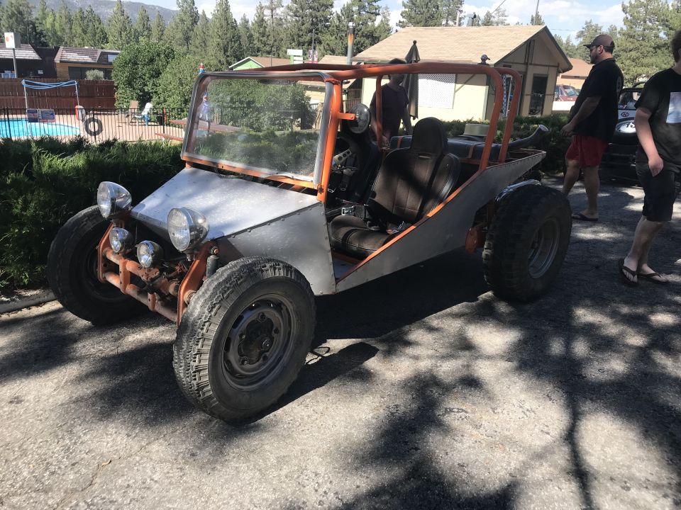 Orange roll cage dune buggy with silver front and large tires