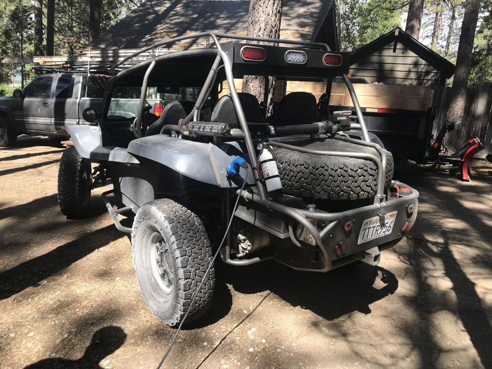Custom dune buggy, rear view, with roll cage, spare tire mounted, and license plate 7TTR956