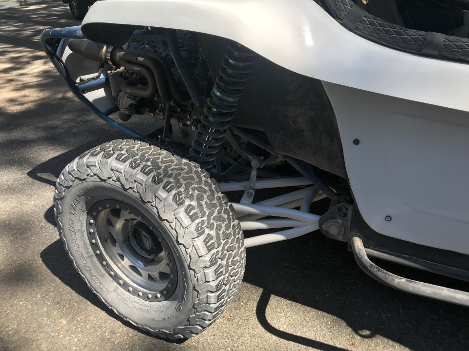 White dune buggy side view, off-road tires, exposed engine components