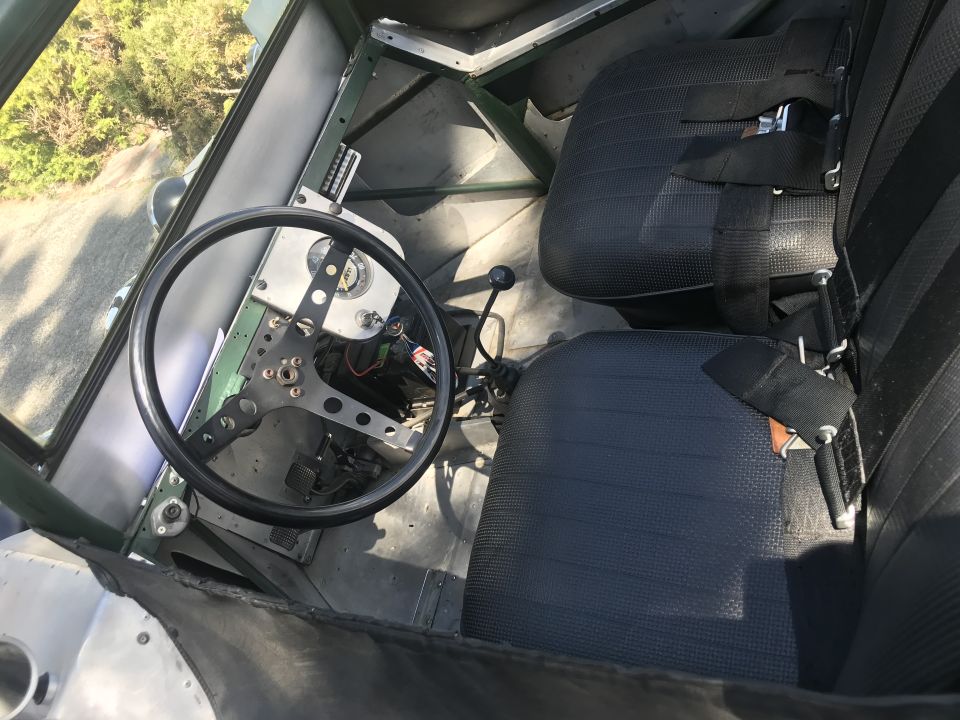 Interior of a custom vehicle with racing seats, steering wheel, and dashboard.