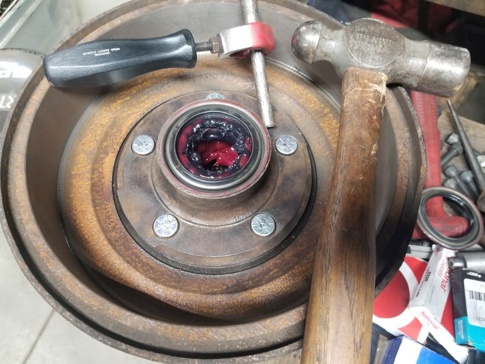 Greased wheel bearing assembly with brake rotor, hammer, and bearing packer tool