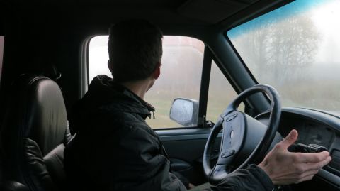 1993 Ford Bronco - Interior view of a person driving a vehicle, looking out the side window. The dashboard and steering wheel are visible in the foreground.