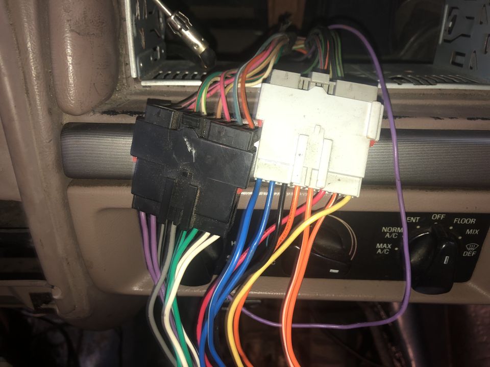 Vehicle dashboard wiring harnesses connected to climate controls.