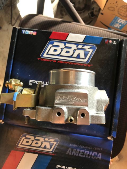 1992 Jeep Wrangler - A silver BBK 62mm throttle body is shown in its original box. The box has the BBK logo and social media icons.